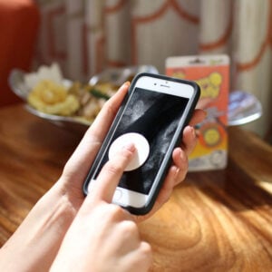 Person using a Screen Daddy to clean a phone