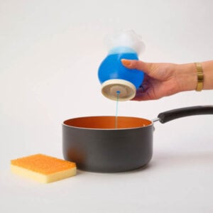 Squirting dish soap from Soap Daddy into a pot. Sponge Daddy laying next to pot.